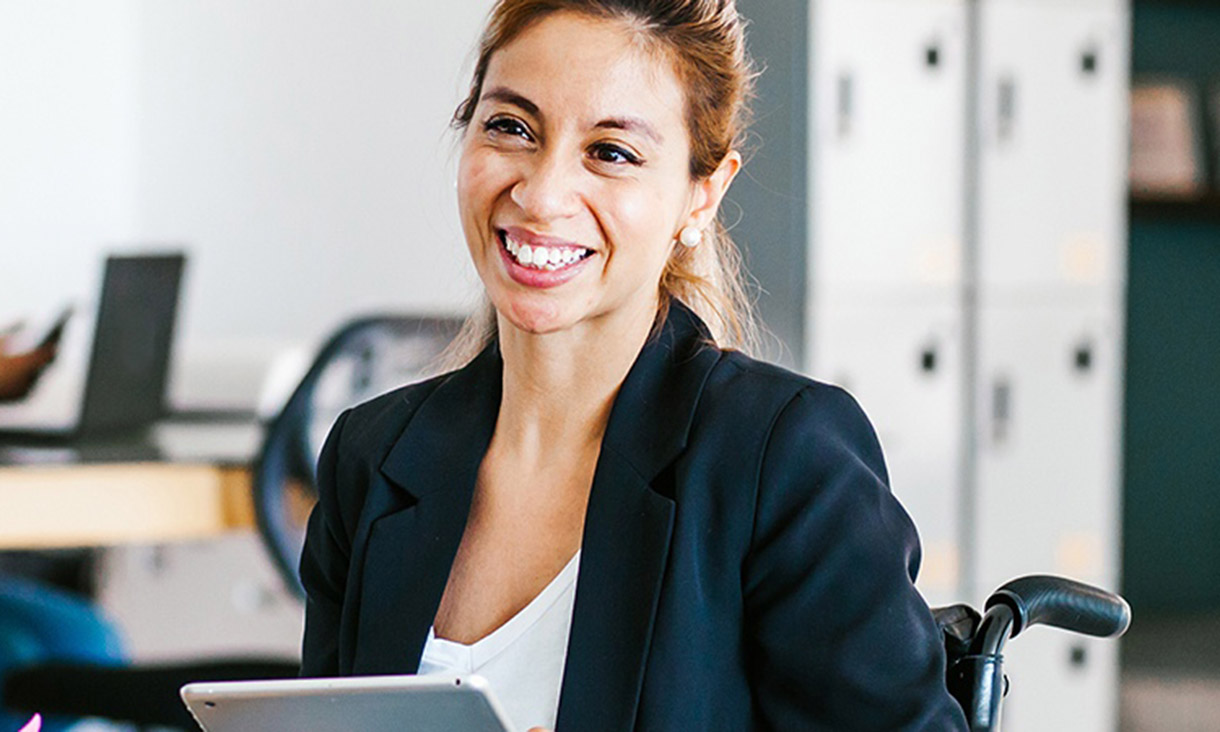 A woman sitting down with a tablet in her hand.