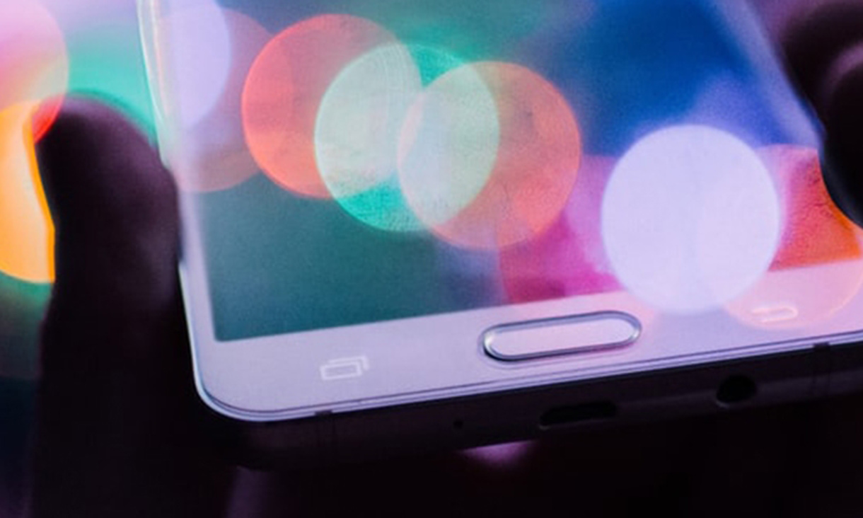 Close up bokeh image of hand holding smart phone.