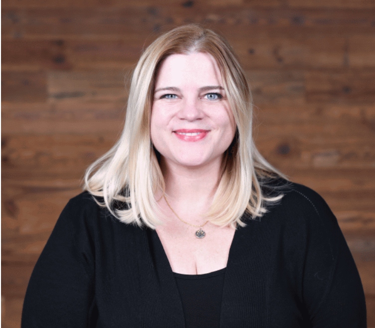 Headshot of Crystal King, she has pale skin, blonde hair and wears black clothing.