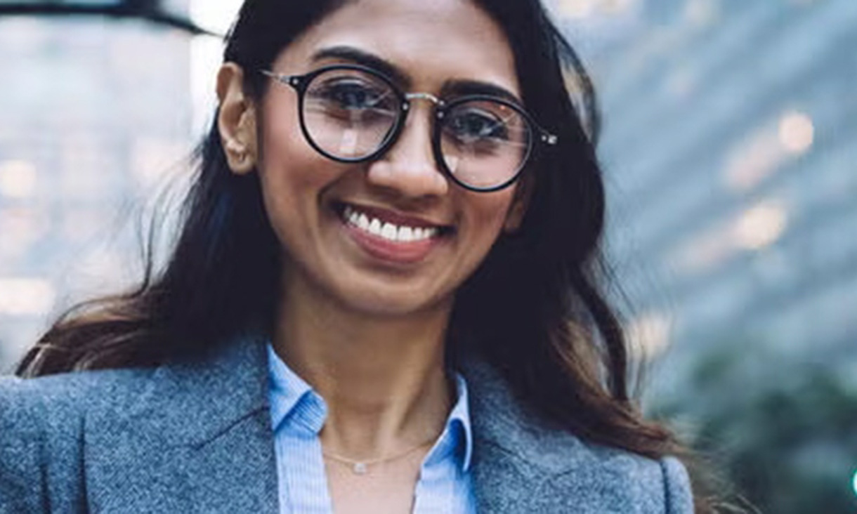 A working professional staring into the camera lens, proud of her achievements.