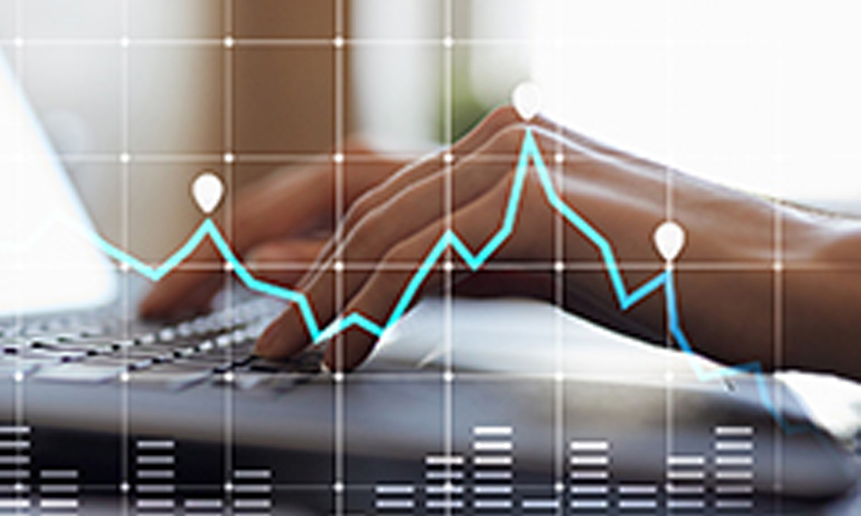 A set of hands on a laptop keyboard with a line graph superimposed on top. 