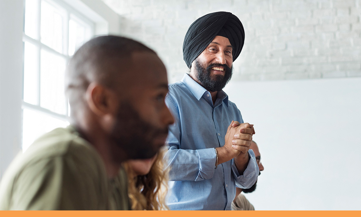 A man stands in a meeting.