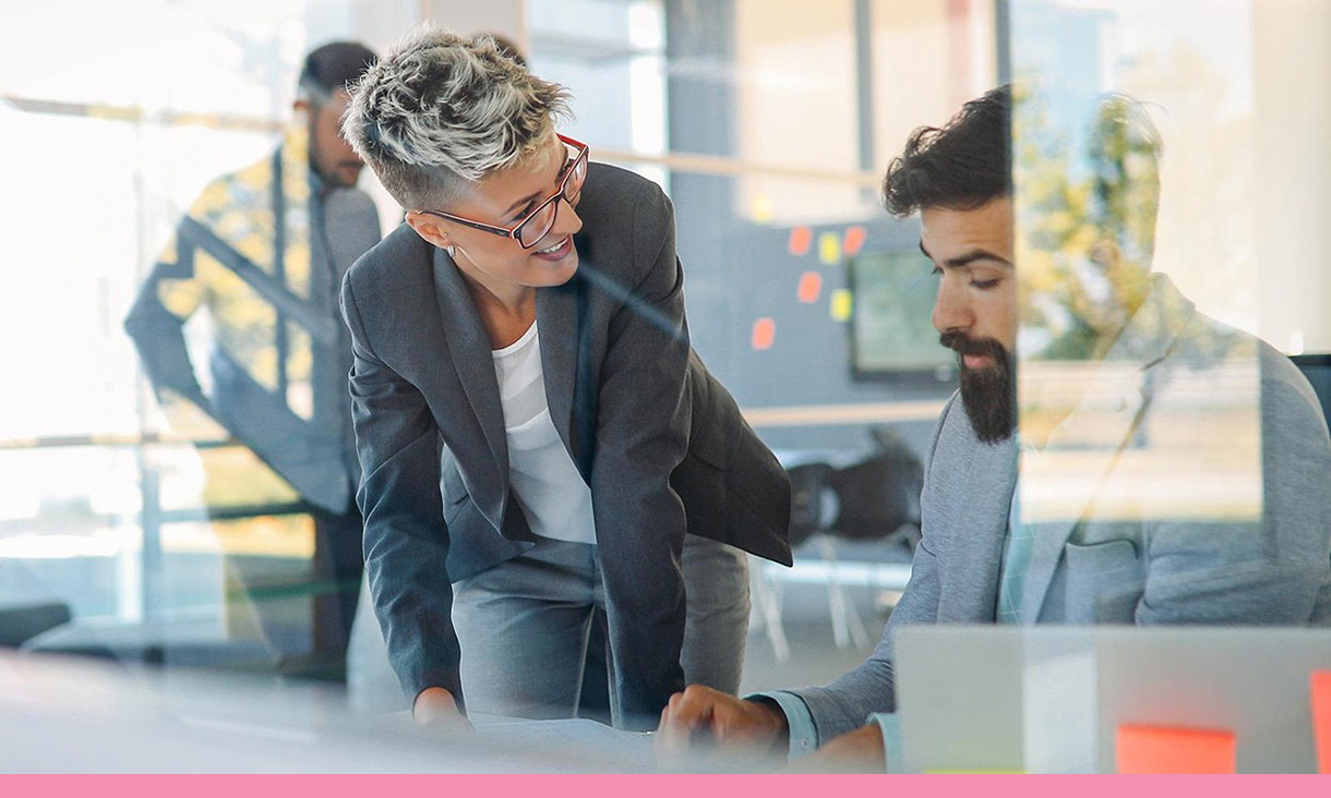 A project manager checks in with an employee.