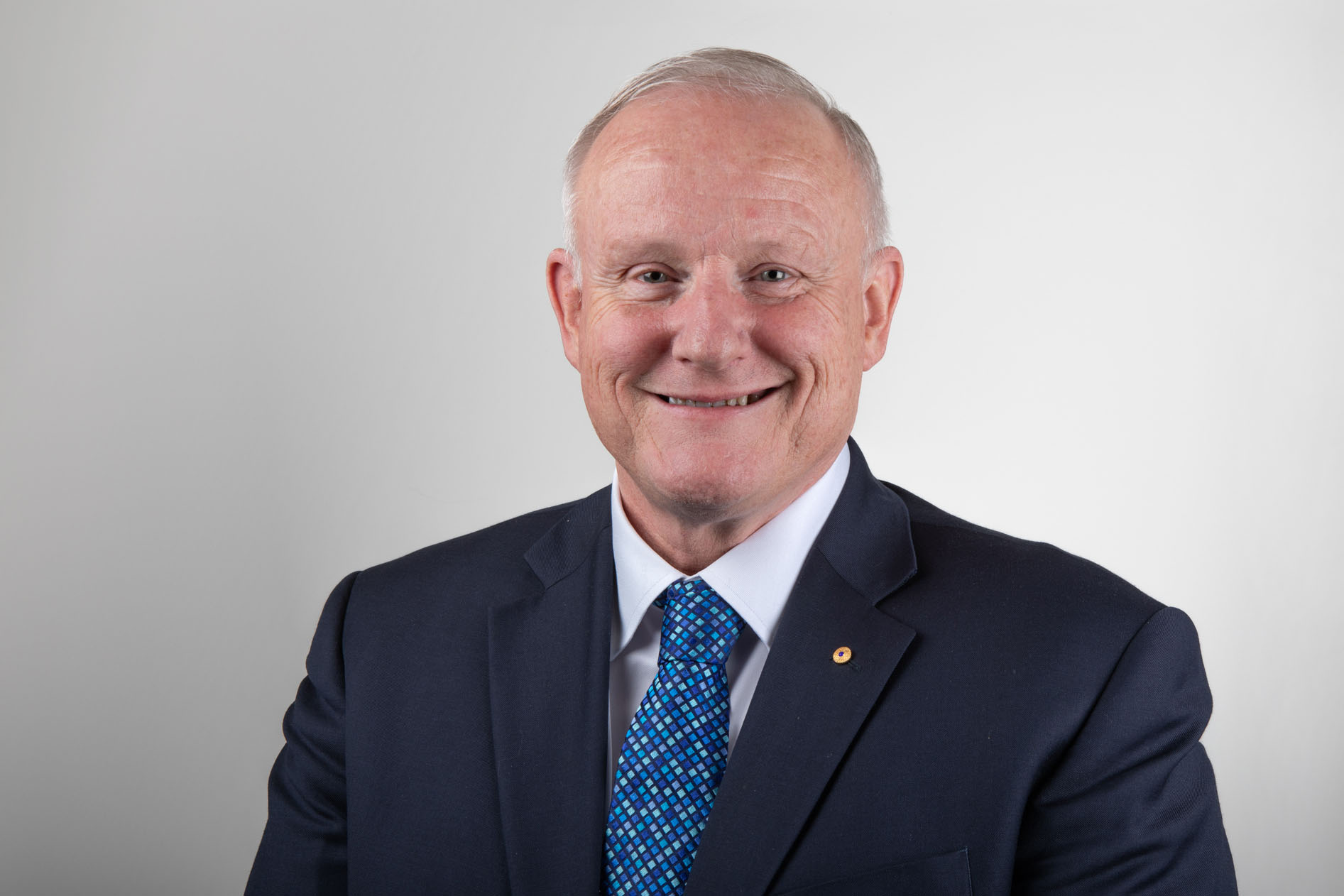 Calum Drummond looking forward and smiling against a solid white background