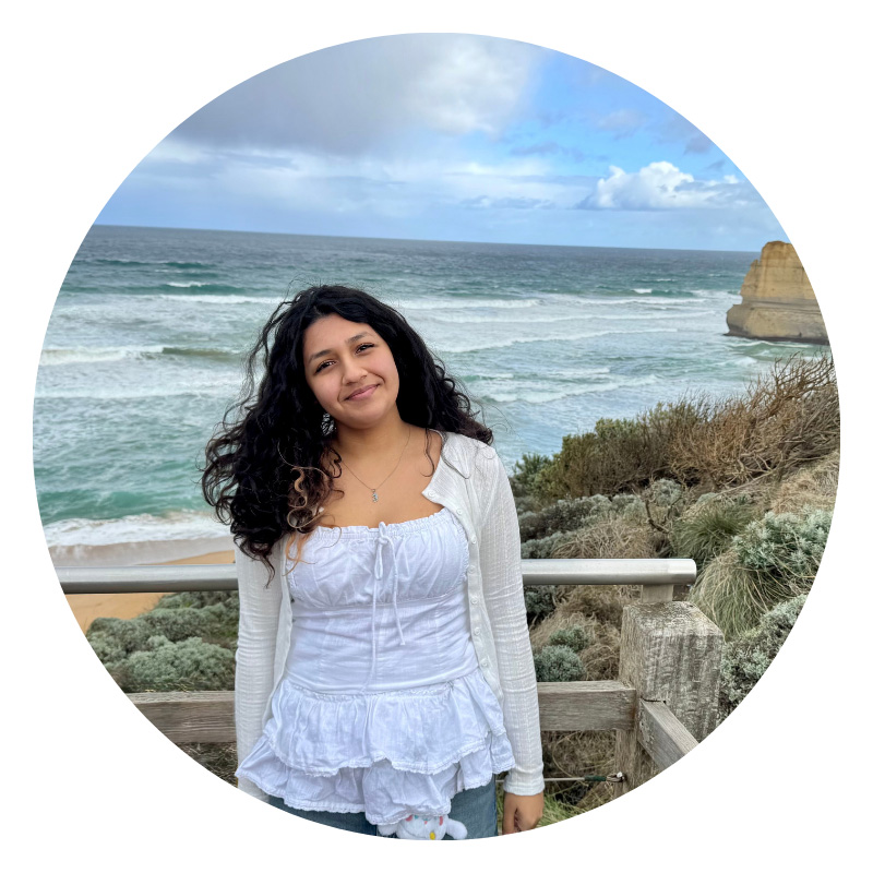 Female student standing at ocean lookout