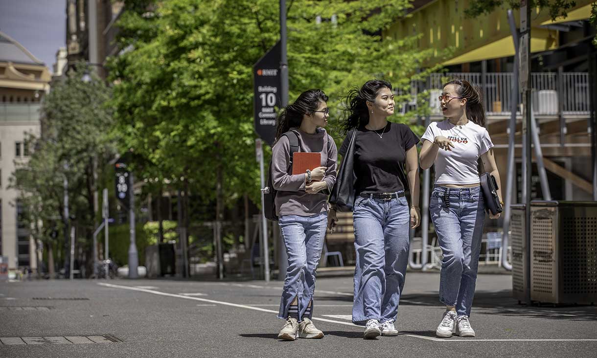 A photograph of three student ambassadors walking together on campus. 