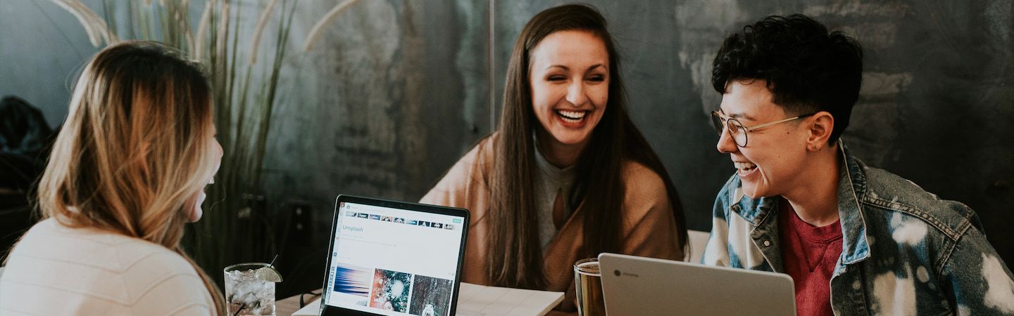 Students on laptops smiling