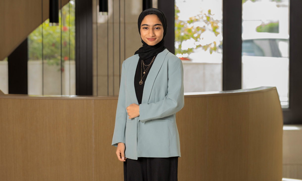 RMIT UP Student Raneem Alrashdi wearing a blazer and standing in front of staircase  
