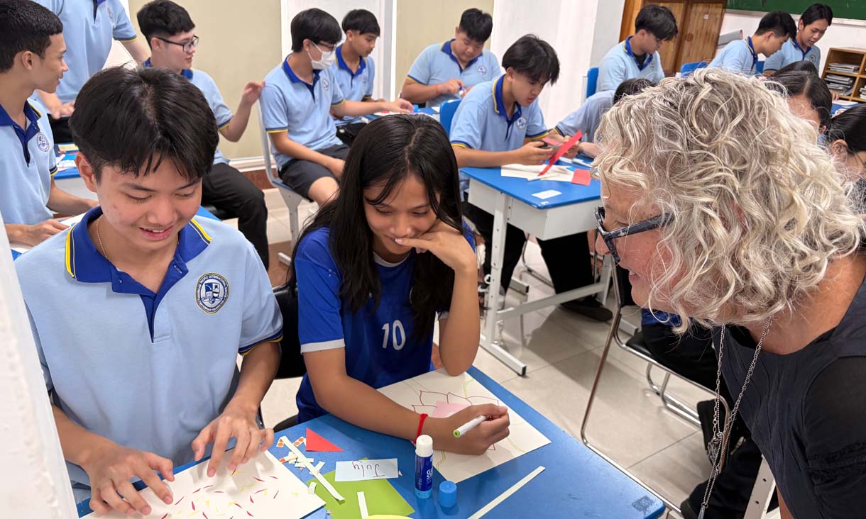 An RMT UP art teacher in a classroom working with students fro m South East Asia