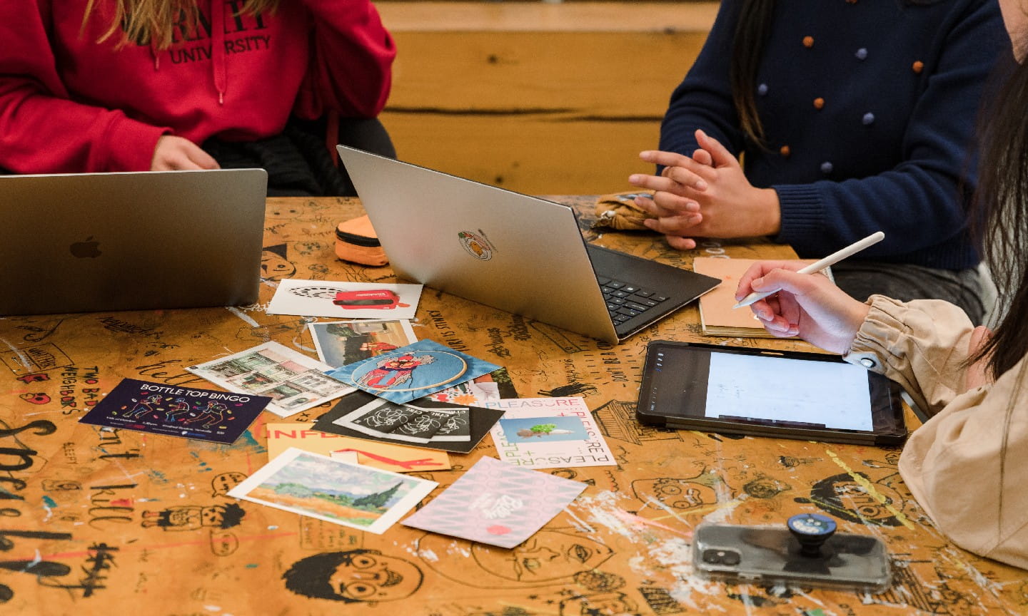 Communication Design students working on laptops and tablets together