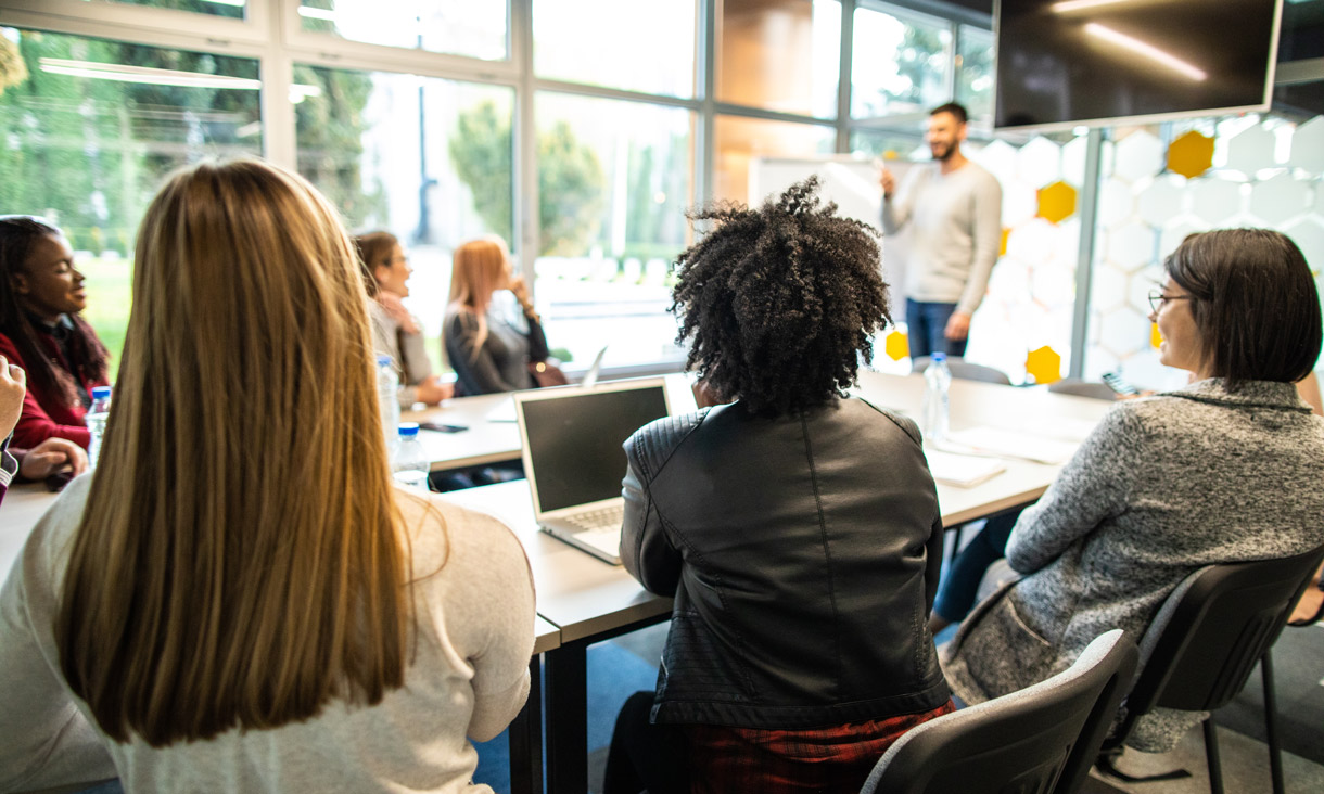 Young businessman leading the meeting in board room, presenting new business plan to his colleagues.