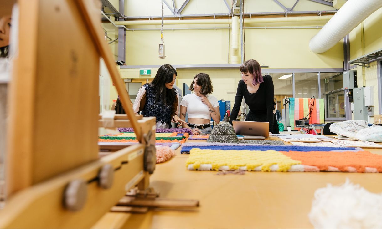 three students talking in class