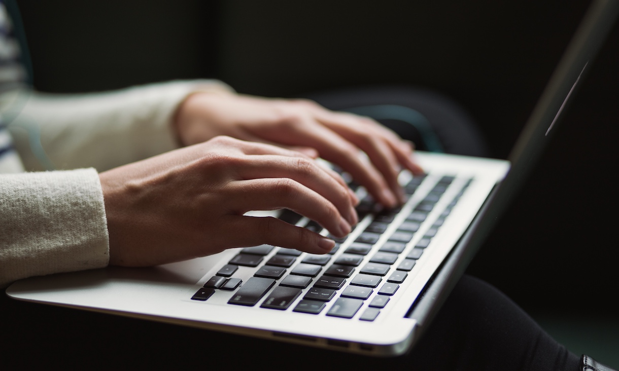 Hands typing on laptop.
