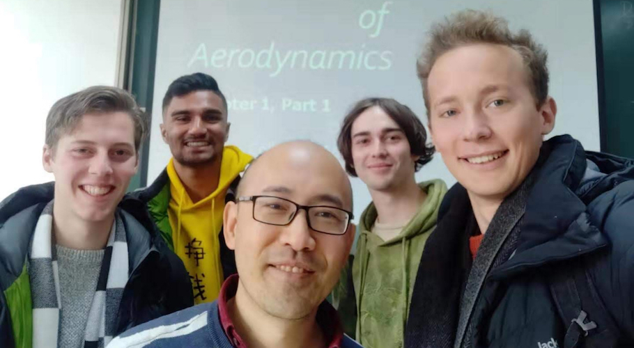 Joshua poses with friends in a Chinese classroom.