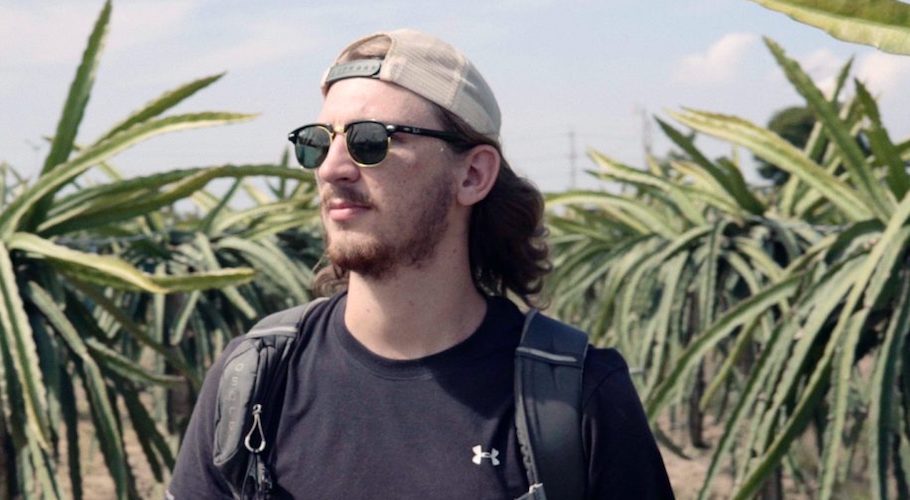 Photo of Joshua wearing a cap in front of trees