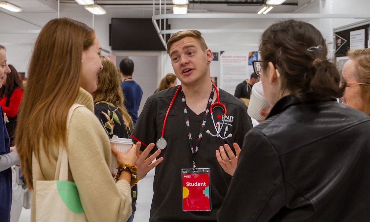 One student explains something to two other students.