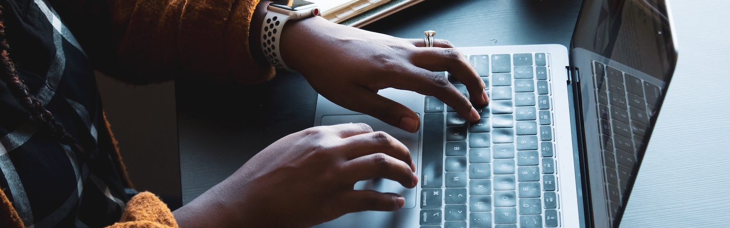 Hands typing on a laptop.