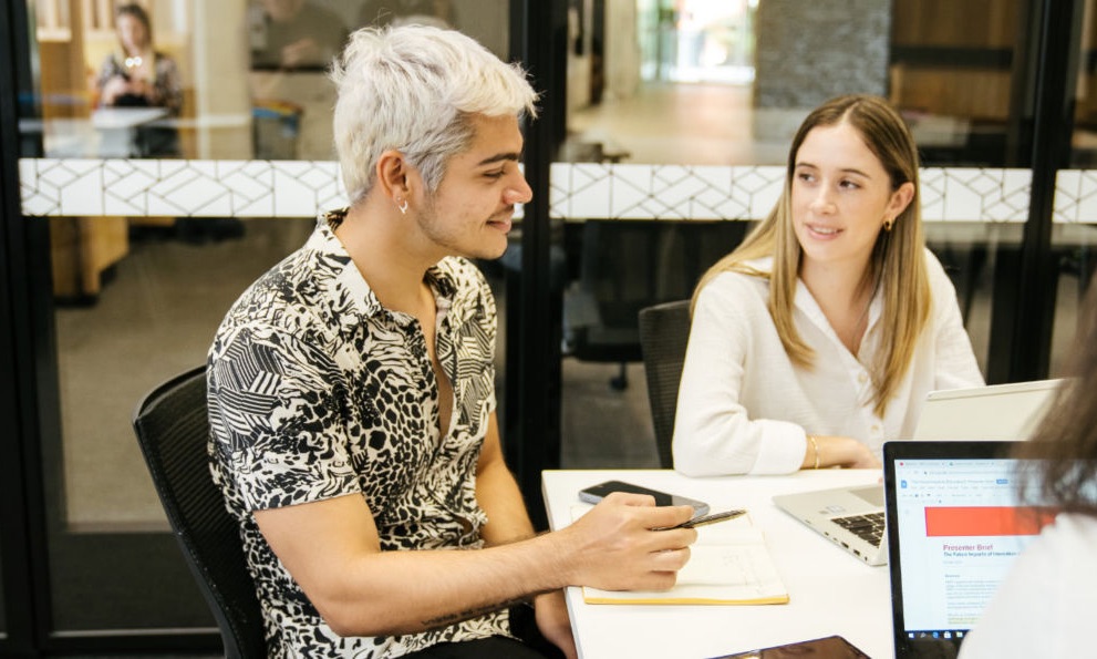 Students chat in a classroom.