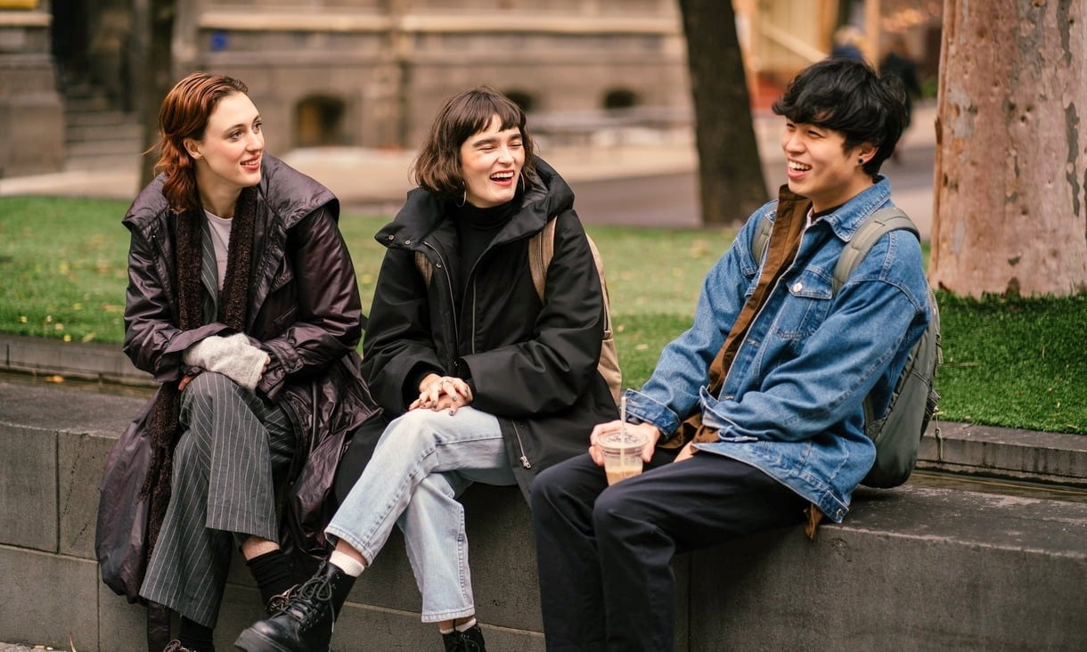 Three people sitting outside