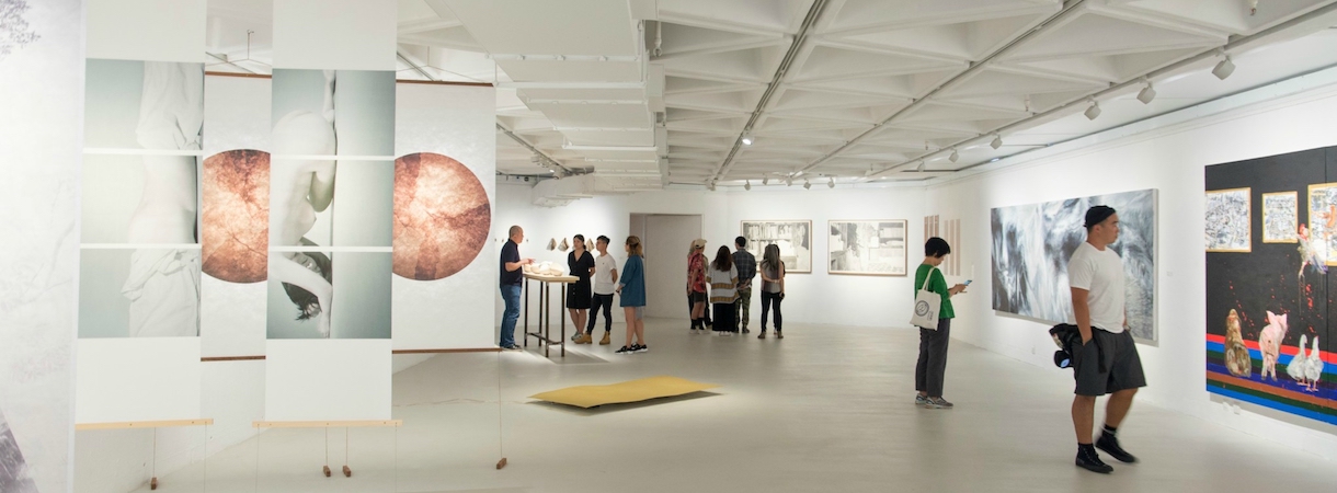 People wander around an art gallery.