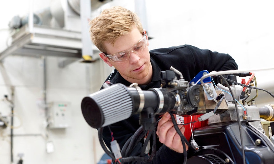 A student works with a machine in a lab.