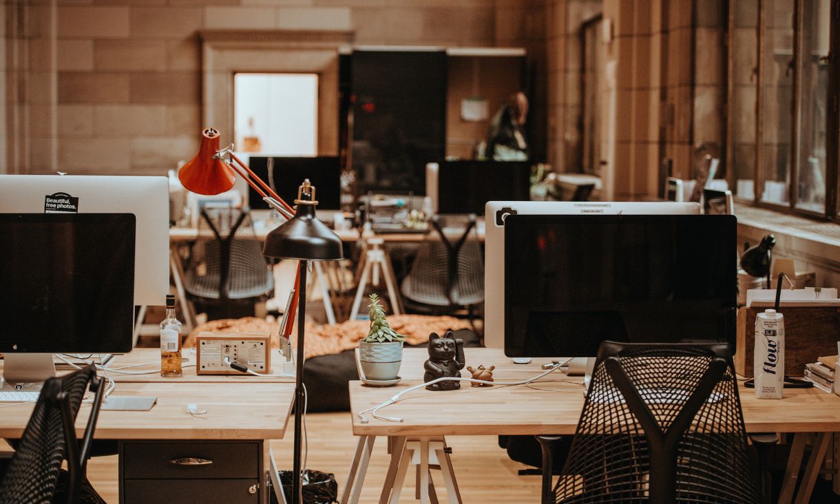 Computers on a desk in a workspace.