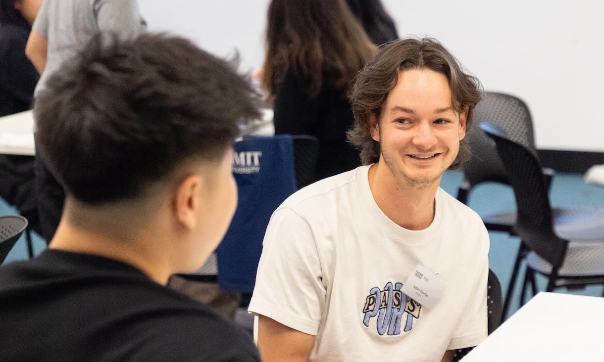 Students at a table talking and smiling