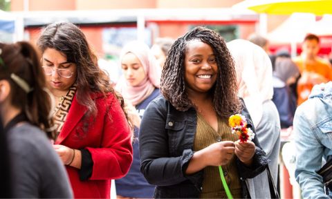 A woman at an outdoor RMIT event smiles at the camera.