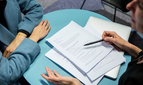 Two people discuss over some paperwork.