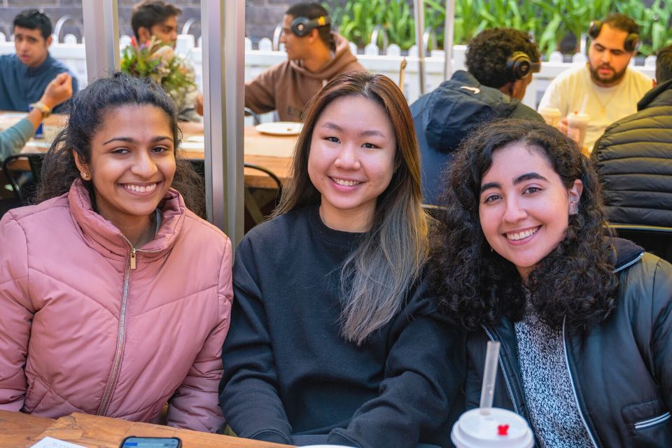 three students smiling toward camera 