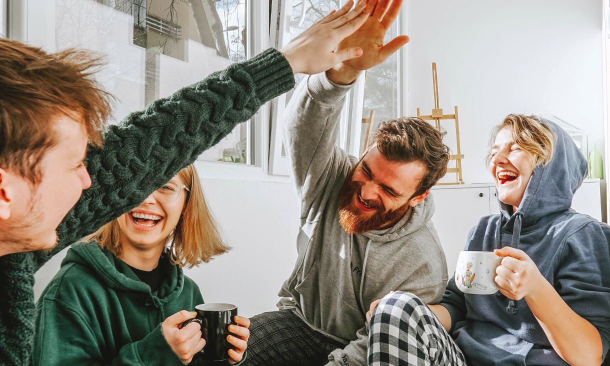 four people sitting around, two high-fiveing 