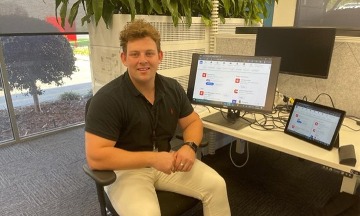 Student Davis McConnell at his internship sitting in front of computer