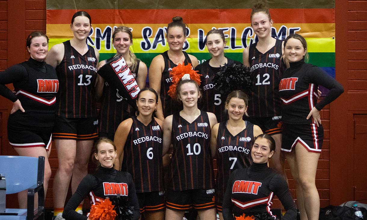 RMIT Cheerleaders in front of inclusion banner