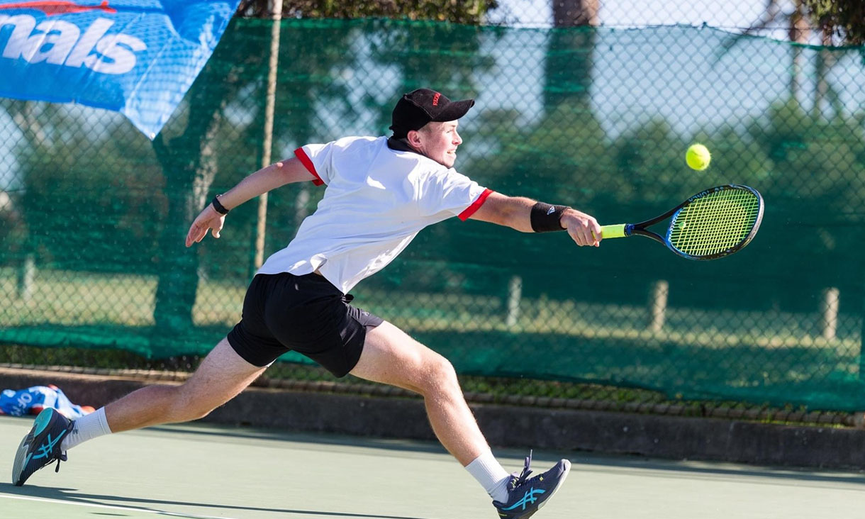 A tennis player stretches out for the ball.