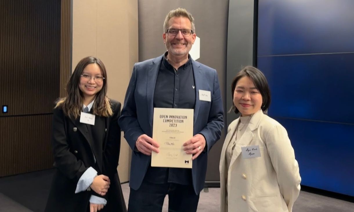 Two students standing with Phil Ore