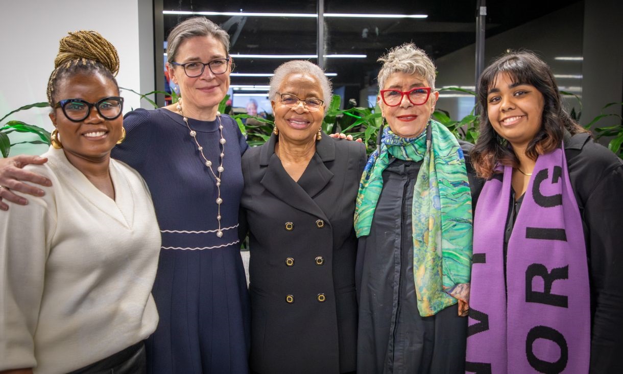 Group of women standing and looking toward camera.