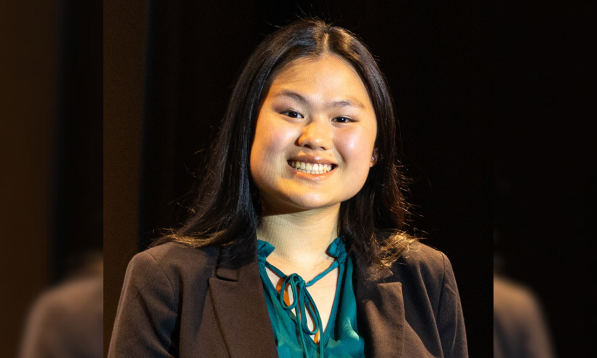 A woman standing in front of a black background