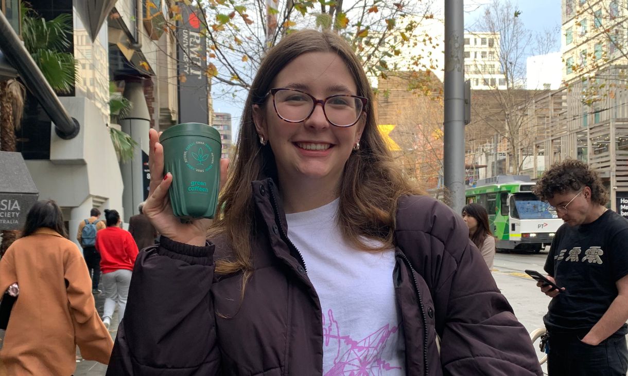 Ella holding a Green Caffeen cup