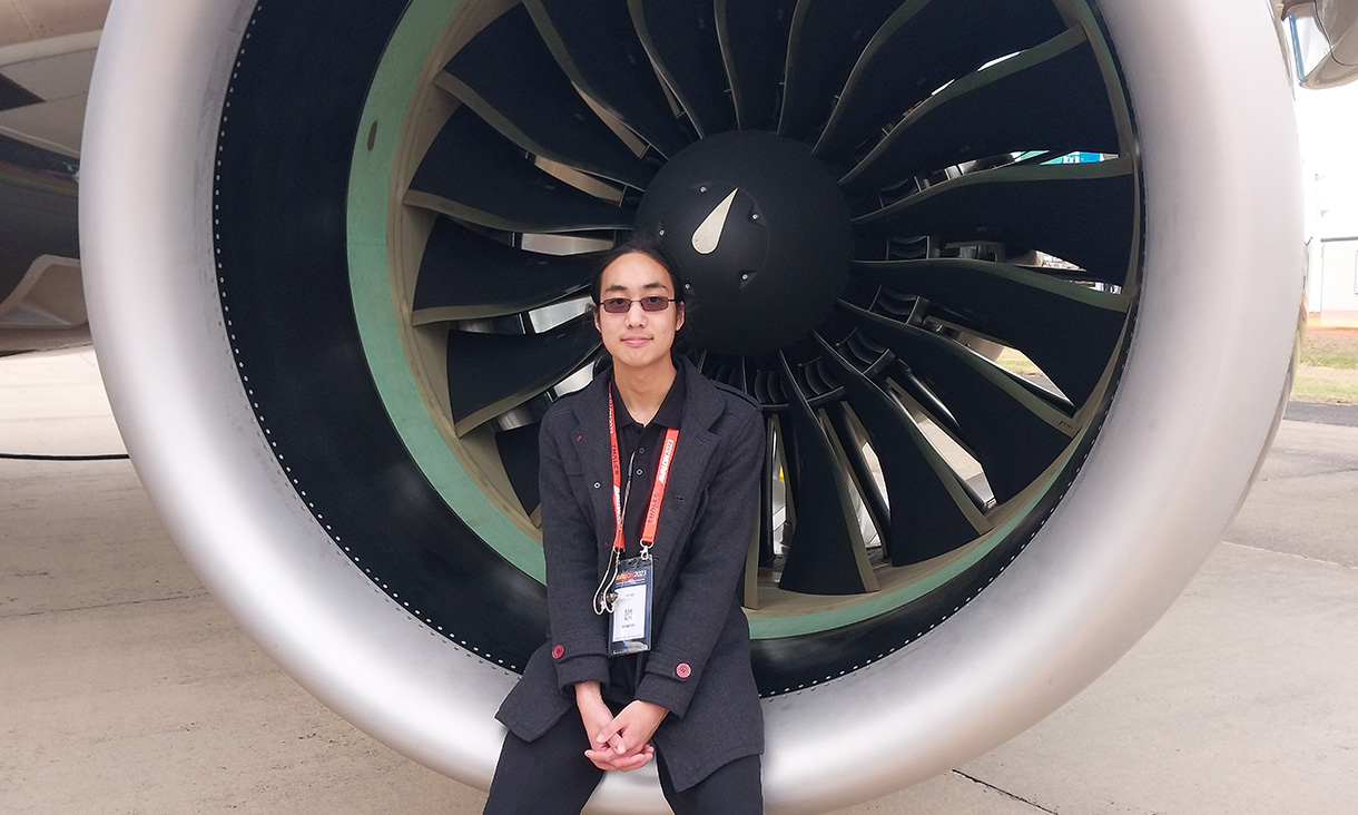 Student sitting on the edge of a plane engine