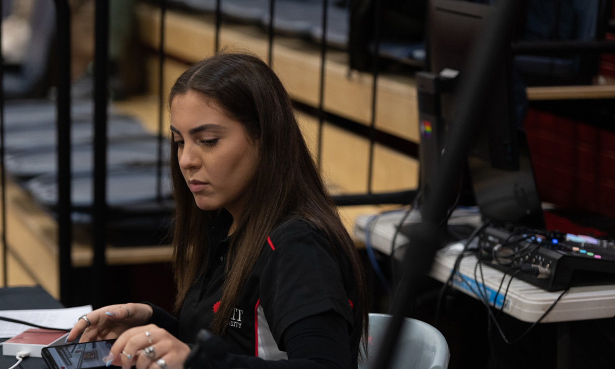 Student at desk looking at their phone.