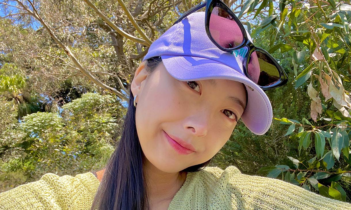 Woman in a purple hat poses for a photo.