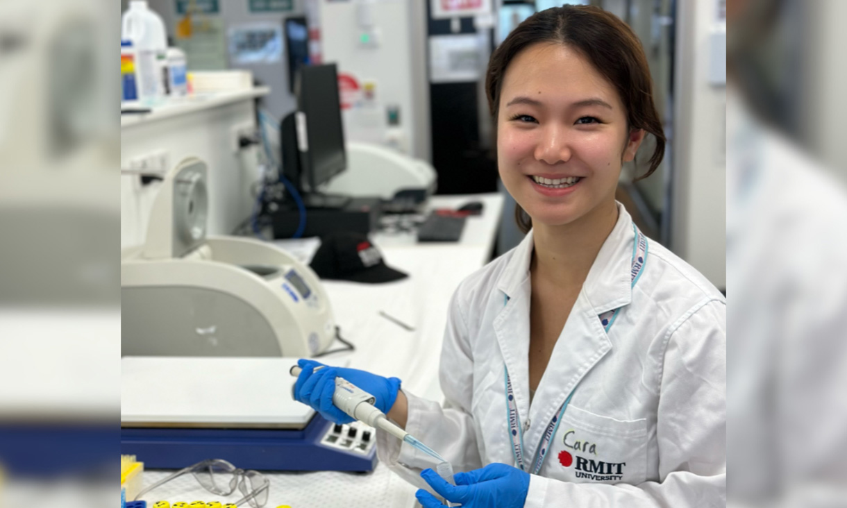 Woman in white lab coat poses for a photo.