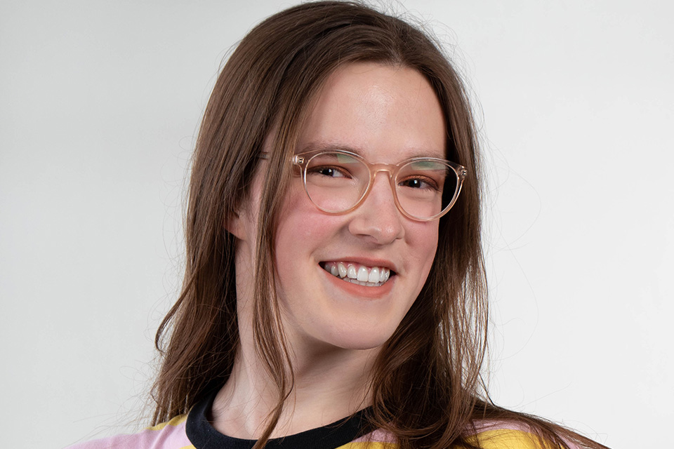 Portrait photo of woman with glasses smiling at camera.