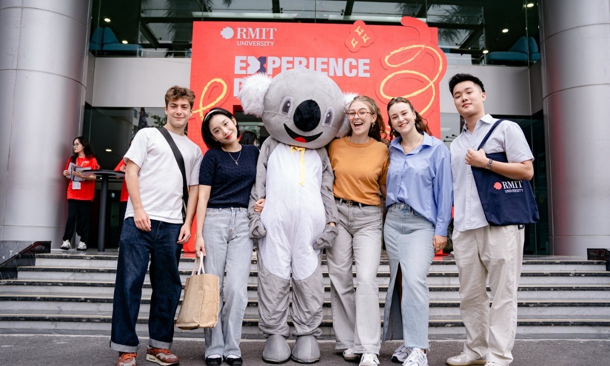Happy students posing with koala mascot in at exchange event