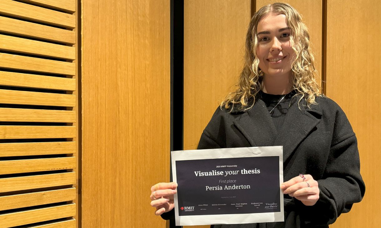 Persia Anderton holding certificate smiling