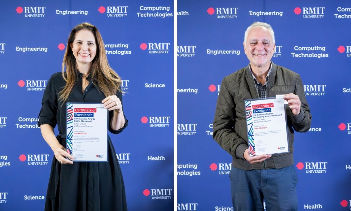 Two individuals pose with certificates in hand, set against a blue wall.