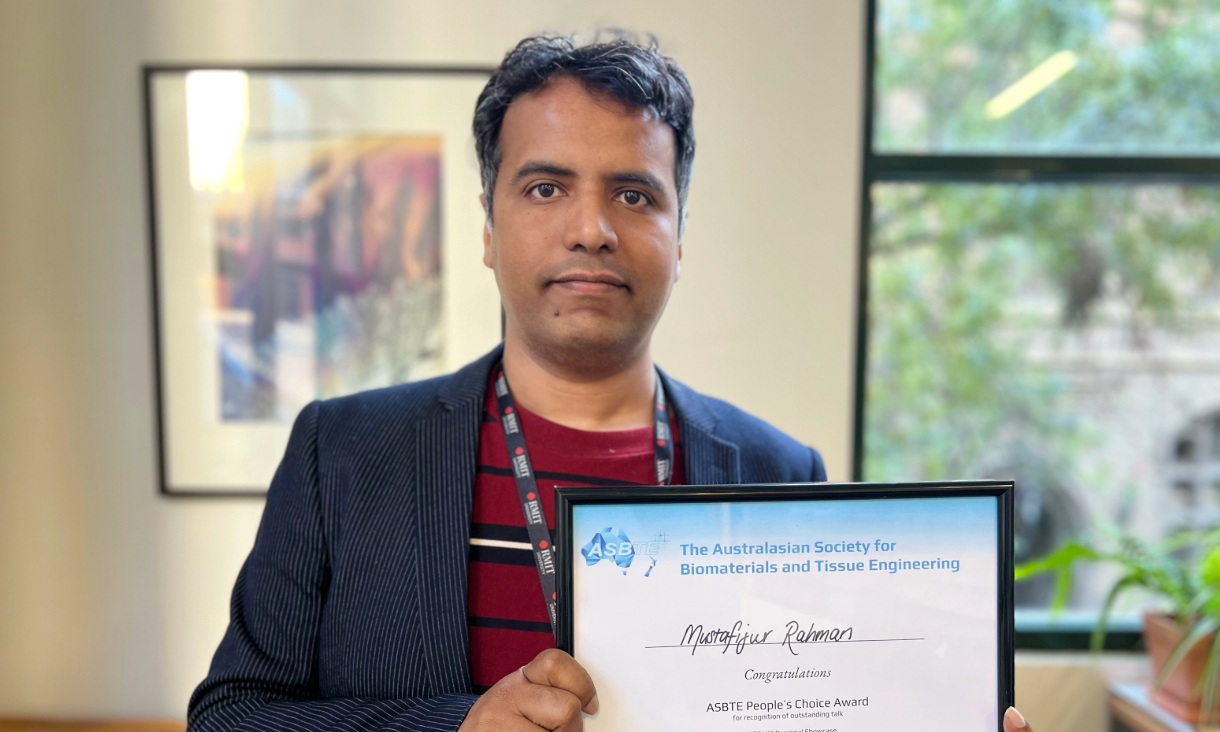 A man holding a certificate posing for a photo.