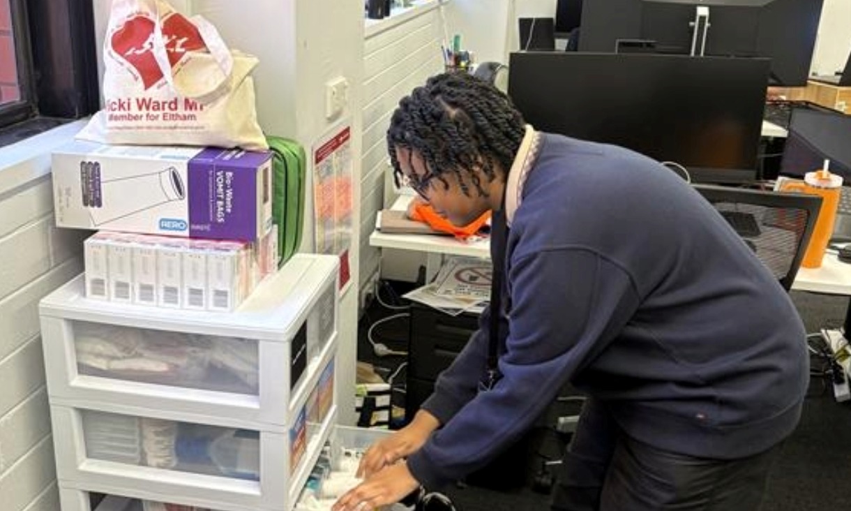 Person leaning over while searching through a clear drawer.
