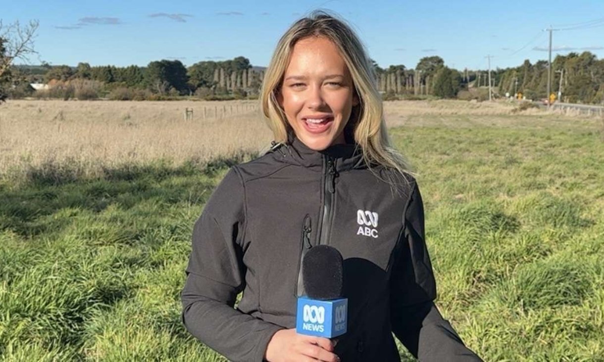 Person holding microphone standing in field