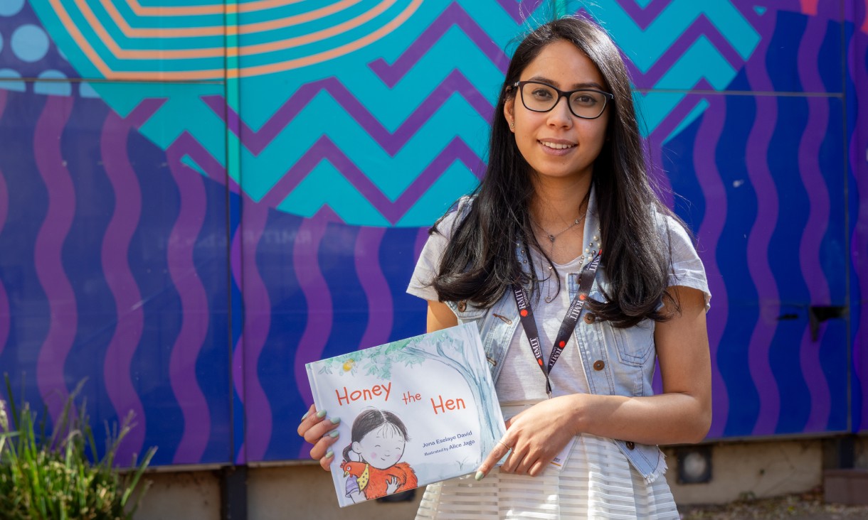 Person holding book standing outside